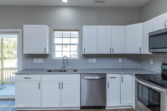 kitchen with sink, white cabinetry, stainless steel appliances, and a wealth of natural light