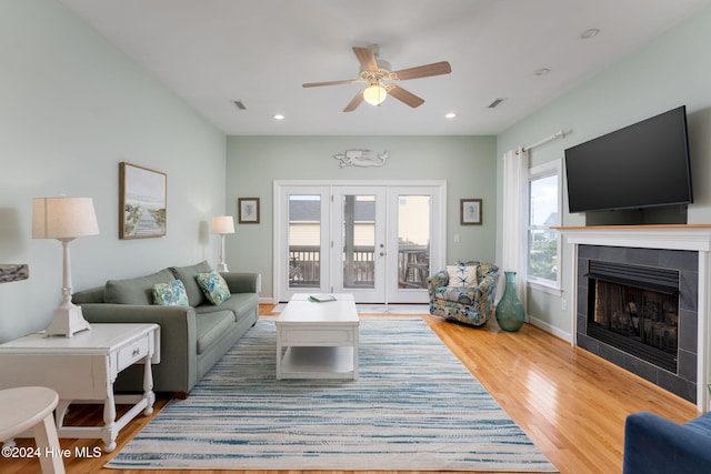 living room with a fireplace, wood-type flooring, and ceiling fan