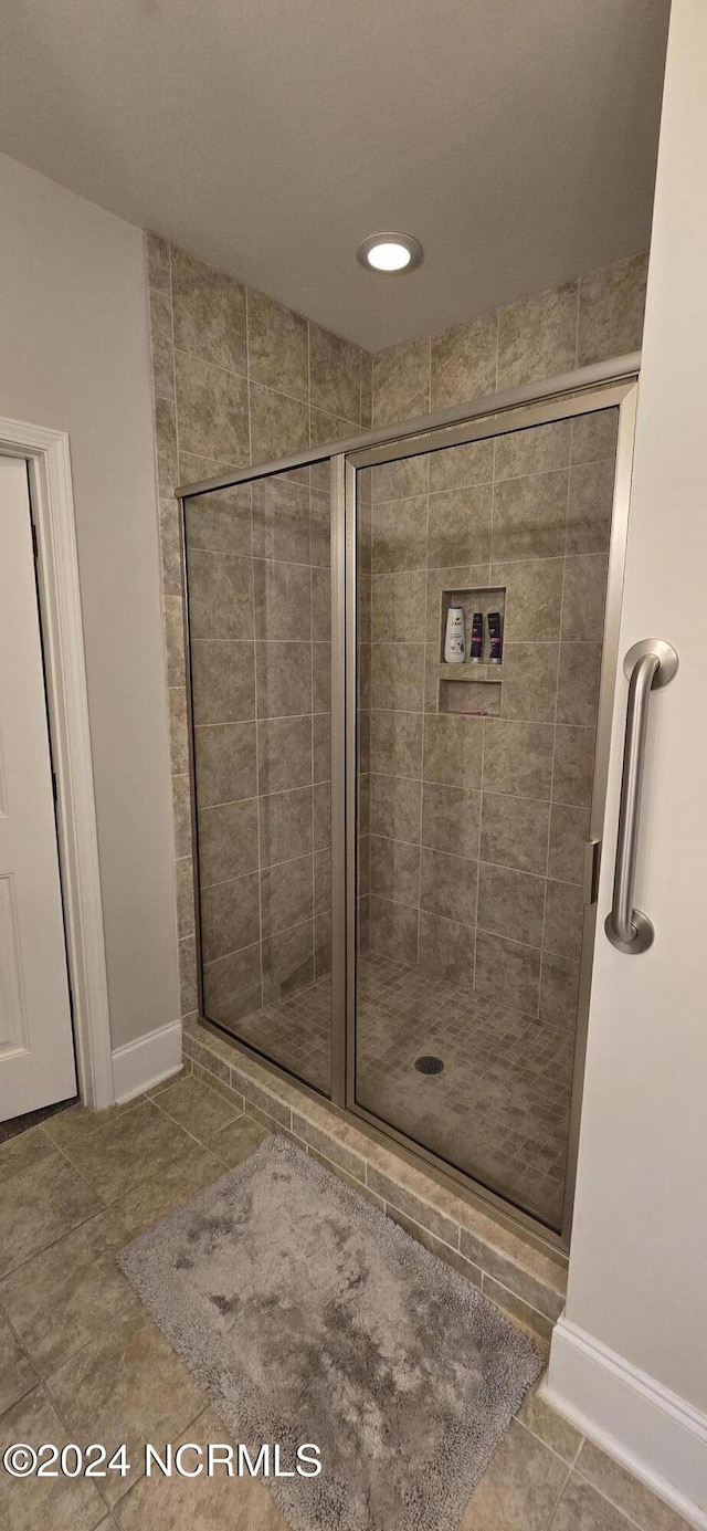 bathroom with tile patterned flooring and a shower with shower door