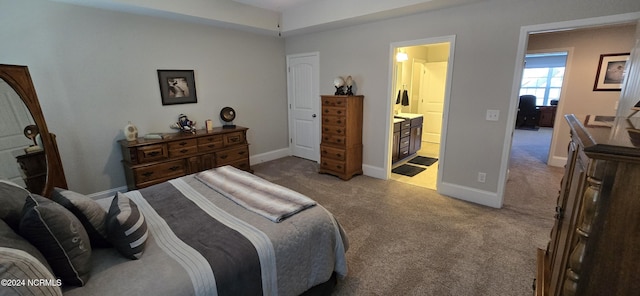 bedroom with connected bathroom and light colored carpet