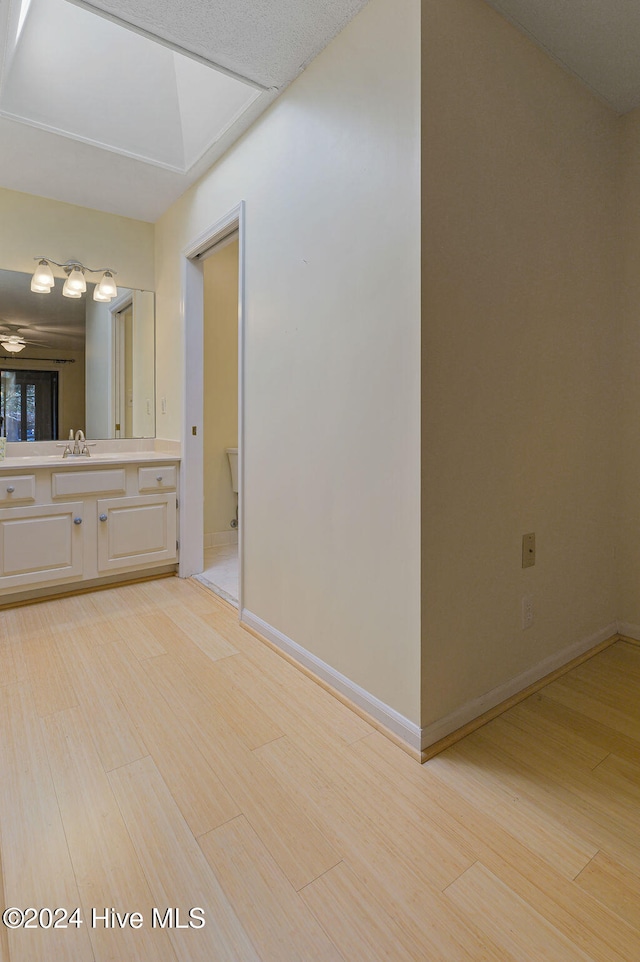 bathroom with vanity, hardwood / wood-style floors, and a skylight