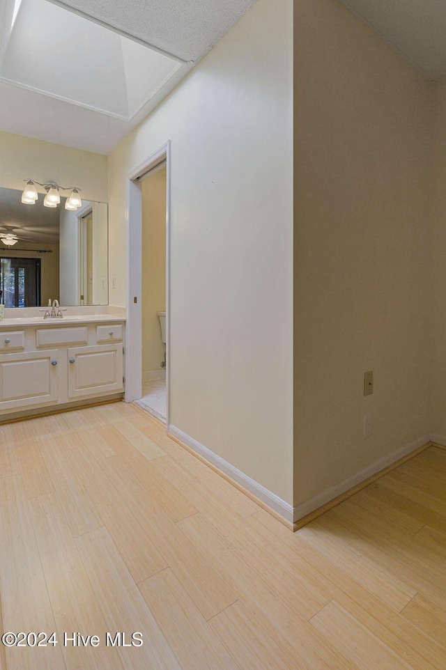 bathroom featuring vanity, baseboards, and wood finished floors