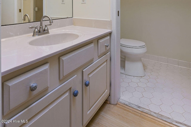 bathroom featuring vanity, hardwood / wood-style flooring, and toilet