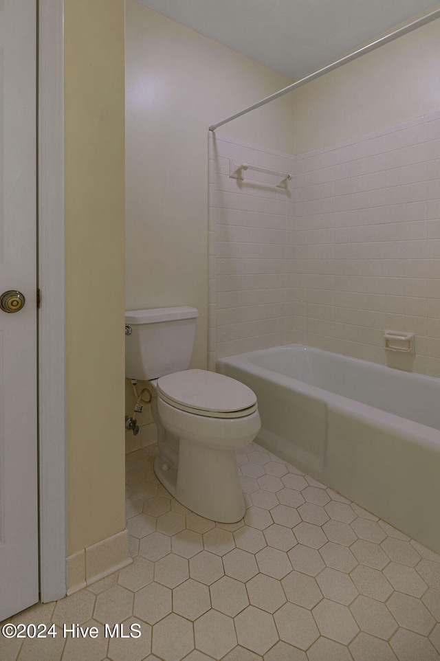 bathroom featuring toilet, shower / bath combination, and tile patterned floors