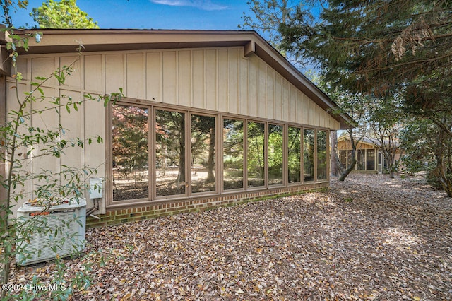 view of side of home with cooling unit and a sunroom