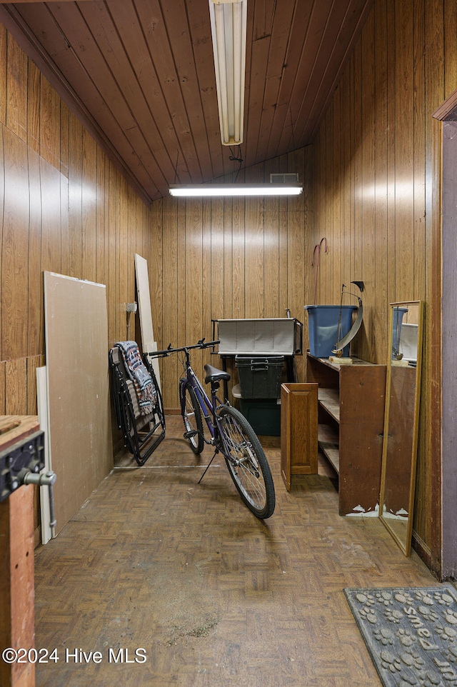 miscellaneous room featuring parquet floors, wood walls, wooden ceiling, and lofted ceiling