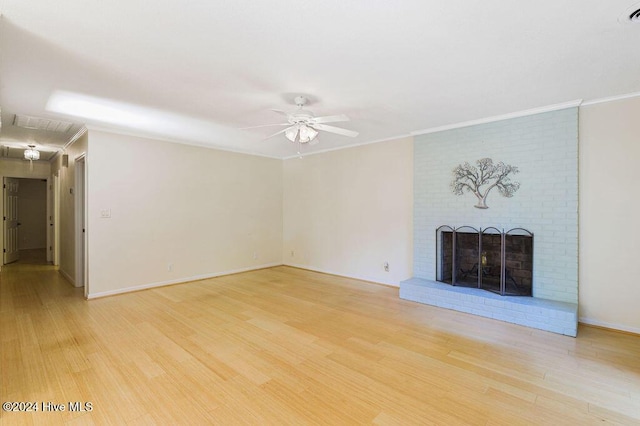 unfurnished living room with a ceiling fan, a brick fireplace, light wood-type flooring, baseboards, and ornamental molding