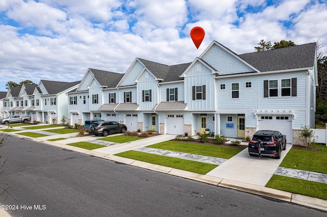 townhome / multi-family property featuring a front yard and a garage