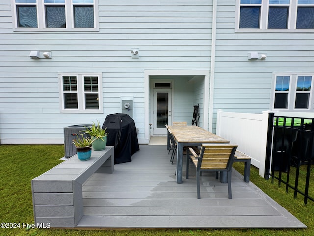 wooden deck with a yard, grilling area, and cooling unit