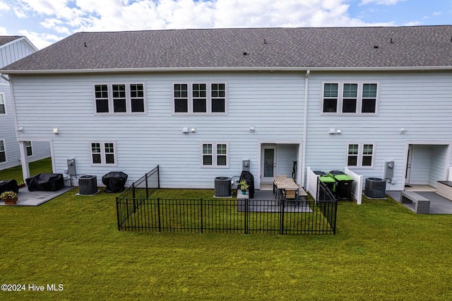 back of property with central air condition unit, a patio, and a lawn