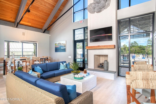 living room with wood ceiling, high vaulted ceiling, light hardwood / wood-style flooring, beamed ceiling, and a fireplace