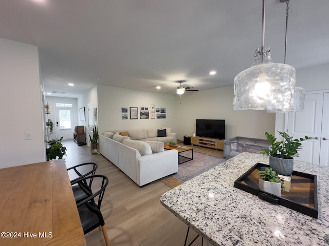 living room with light hardwood / wood-style floors and ceiling fan