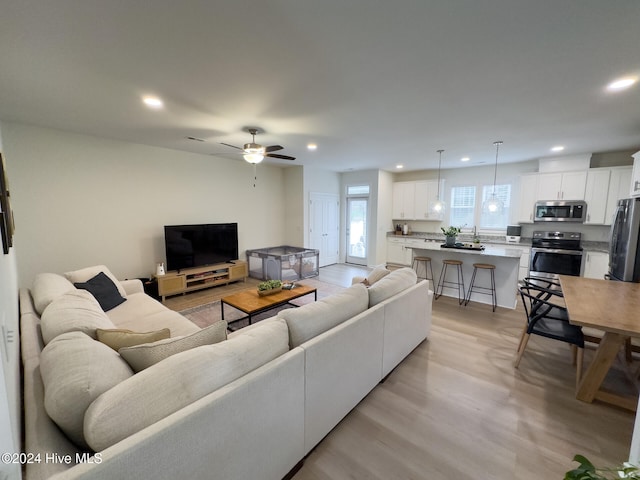 living room featuring light hardwood / wood-style floors and ceiling fan