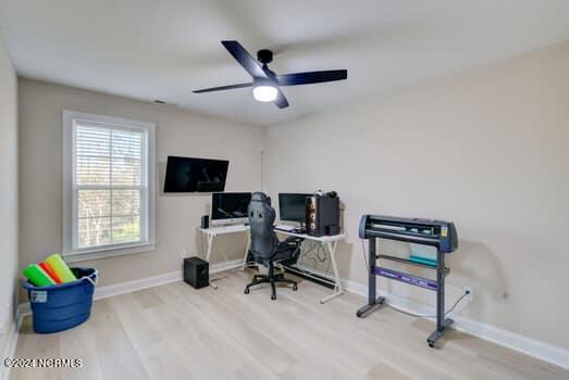 bedroom featuring sink, crown molding, a raised ceiling, and light wood-type flooring