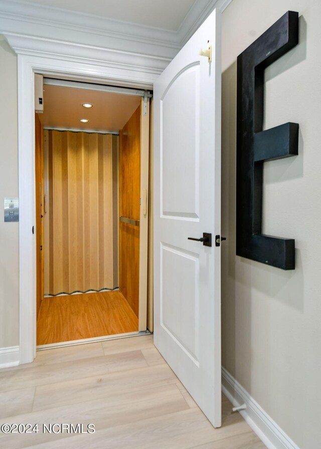 bedroom with ceiling fan, ornamental molding, a tray ceiling, and light hardwood / wood-style floors