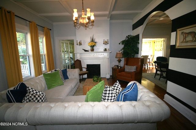 living room featuring beam ceiling, dark hardwood / wood-style flooring, crown molding, a notable chandelier, and coffered ceiling