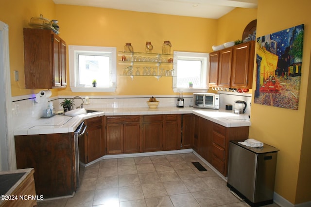 kitchen featuring tile countertops, sink, and appliances with stainless steel finishes