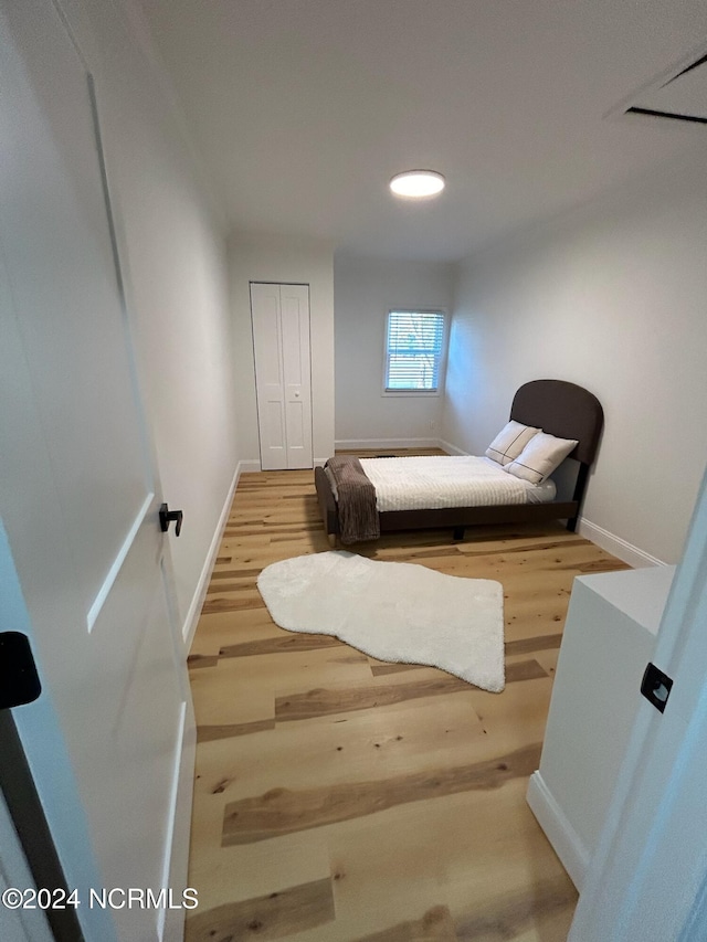 bedroom with baseboards and wood finished floors