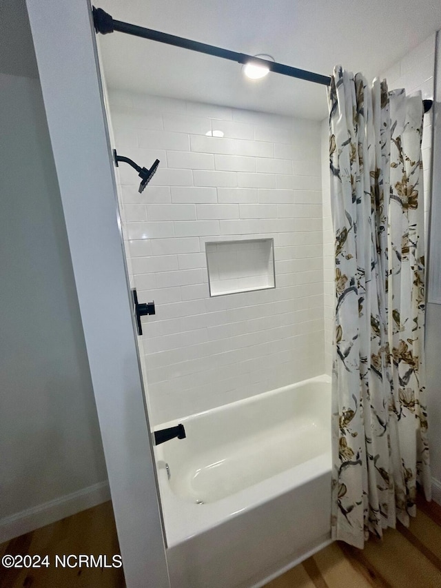 full bath featuring baseboards and shower / bathtub combination with curtain