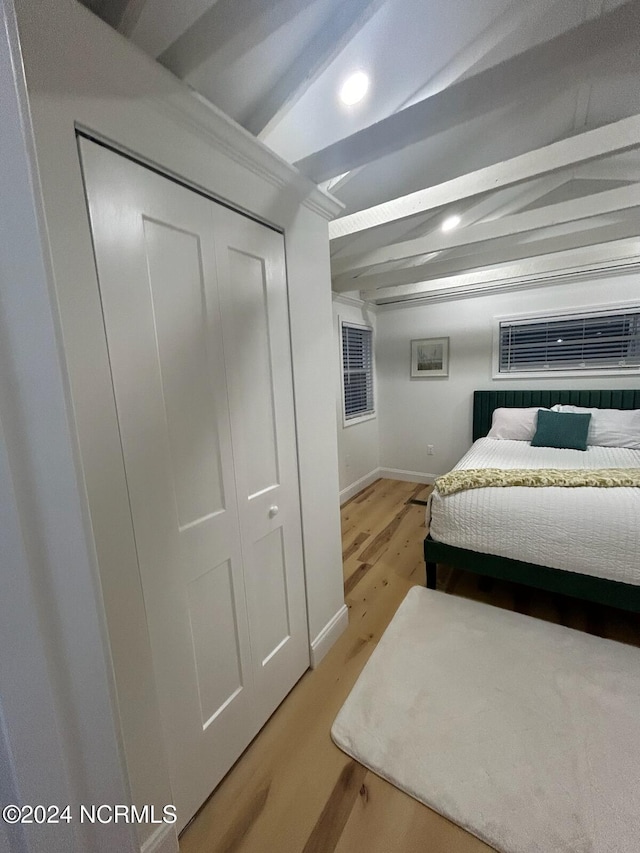 bedroom featuring beam ceiling, baseboards, a closet, recessed lighting, and light wood-style flooring