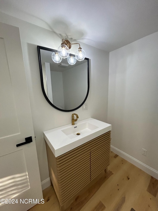 bathroom with baseboards, wood finished floors, and vanity