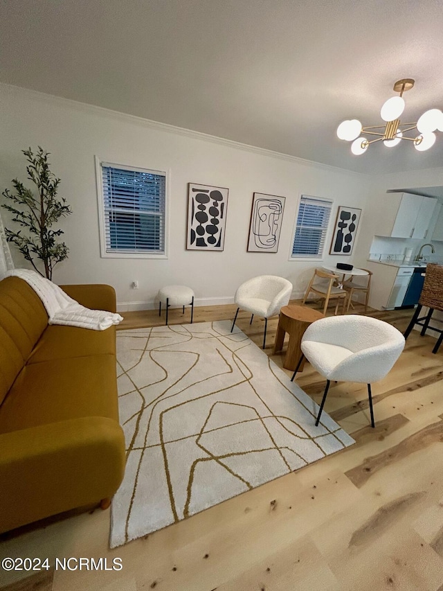 living room featuring crown molding, a notable chandelier, and wood finished floors