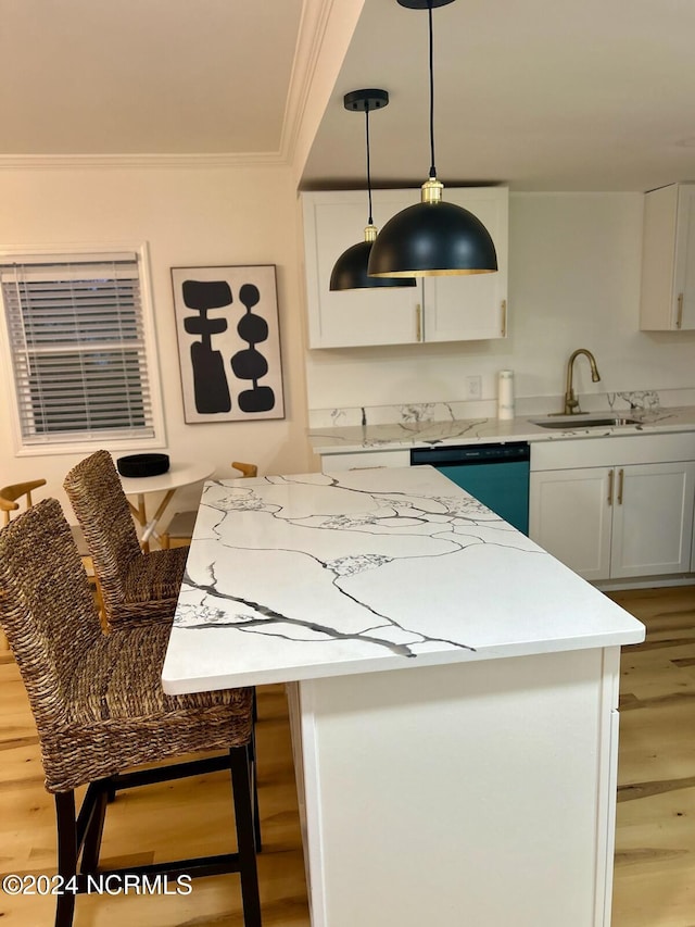 kitchen with light hardwood / wood-style floors, white cabinets, and decorative light fixtures