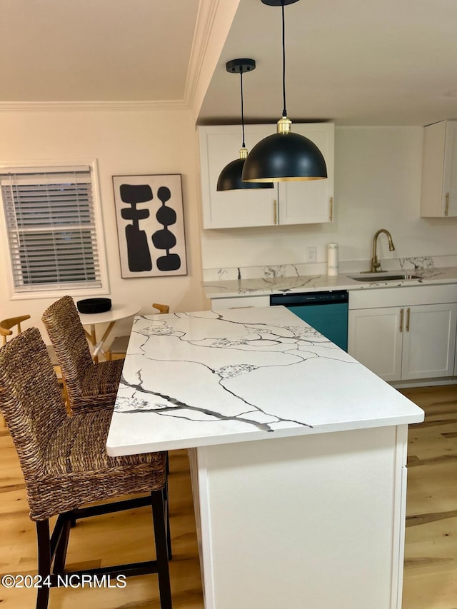 kitchen with a kitchen island, crown molding, a sink, dishwashing machine, and light wood-style floors