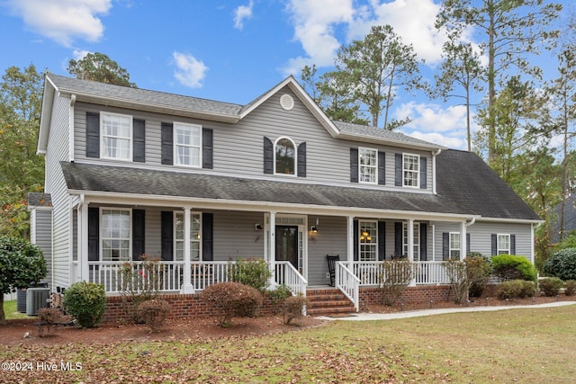 view of front of home with a front yard and central AC