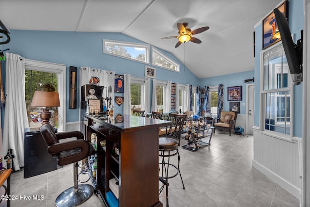 kitchen featuring a kitchen breakfast bar, ceiling fan, and vaulted ceiling