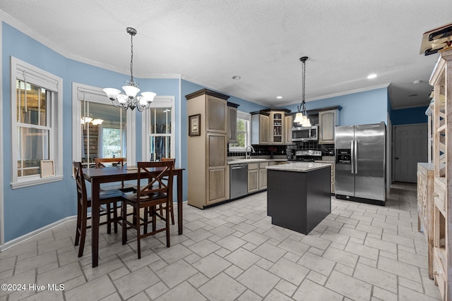 kitchen with appliances with stainless steel finishes, backsplash, crown molding, an inviting chandelier, and a center island