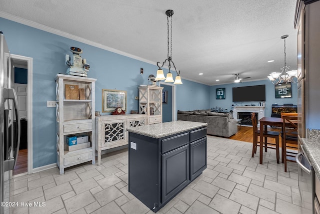 kitchen featuring a textured ceiling, ceiling fan, crown molding, pendant lighting, and a kitchen island