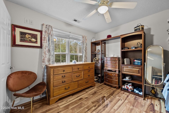 interior space featuring a textured ceiling, light wood-type flooring, and ceiling fan