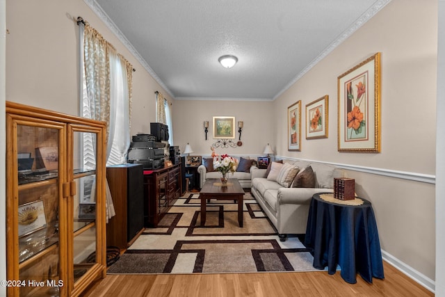 living room with a textured ceiling, light hardwood / wood-style floors, and ornamental molding