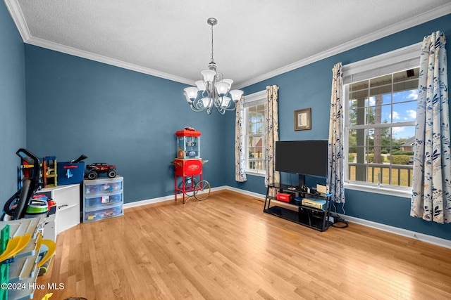 game room with a chandelier, a textured ceiling, hardwood / wood-style flooring, and crown molding