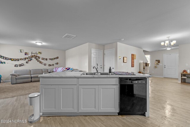 kitchen with black dishwasher, sink, a notable chandelier, and light hardwood / wood-style floors