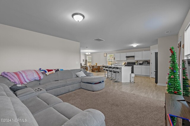 living room with light hardwood / wood-style flooring and an inviting chandelier