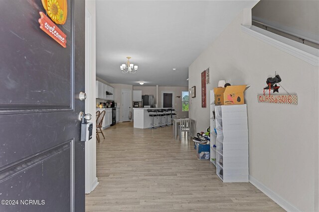 entrance foyer featuring light hardwood / wood-style flooring and a chandelier