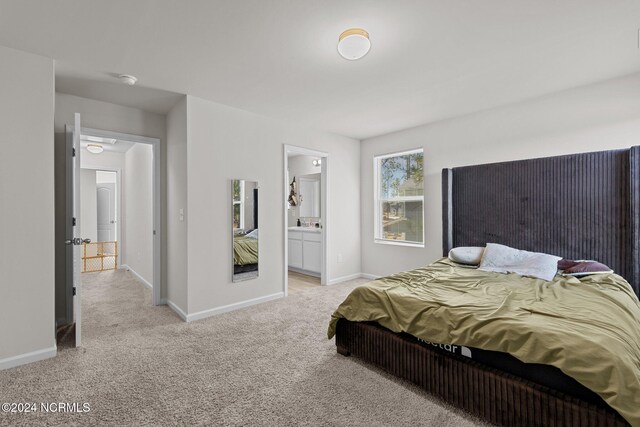 carpeted bedroom featuring ensuite bath