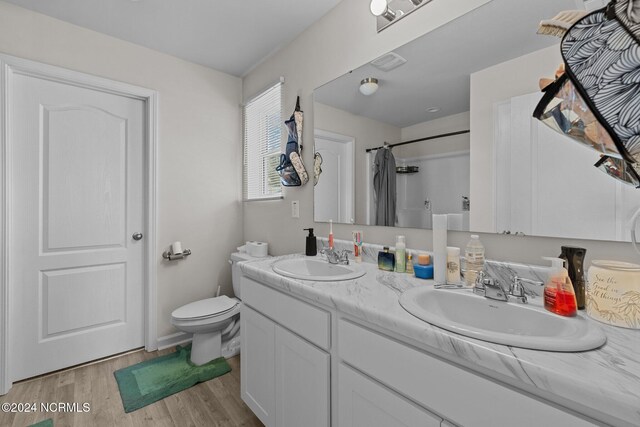 bathroom with vanity, toilet, hardwood / wood-style flooring, and curtained shower