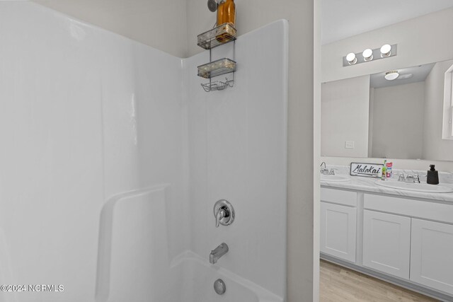 bathroom featuring vanity, hardwood / wood-style flooring, and shower / tub combination