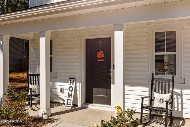 view of exterior entry with a porch