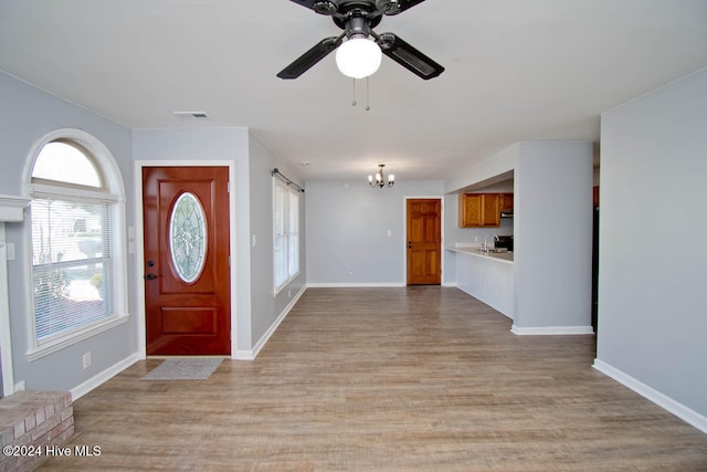 entryway featuring ceiling fan with notable chandelier, sink, and light hardwood / wood-style flooring