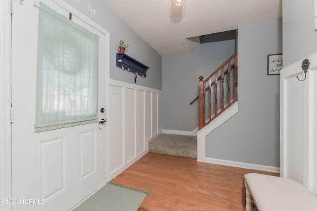 foyer with light hardwood / wood-style flooring and a textured ceiling