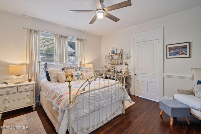 bedroom with ornamental molding, a textured ceiling, ceiling fan, and dark wood-type flooring