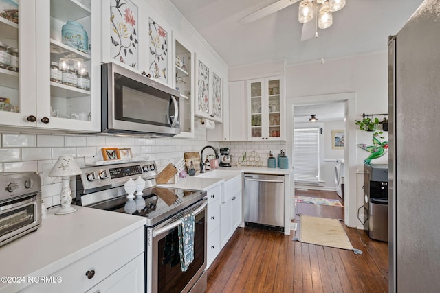 kitchen featuring white cabinets, dark hardwood / wood-style floors, decorative backsplash, ornamental molding, and stainless steel appliances