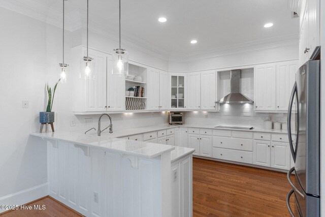 kitchen featuring white cabinets, light stone counters, wall chimney exhaust hood, and stainless steel appliances