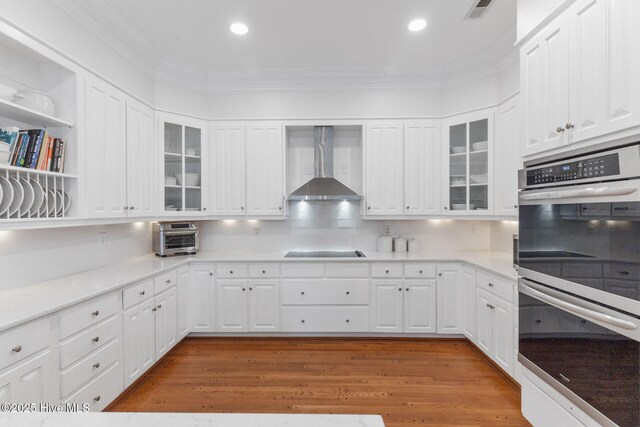 kitchen with kitchen peninsula, sink, stainless steel dishwasher, decorative light fixtures, and white cabinetry