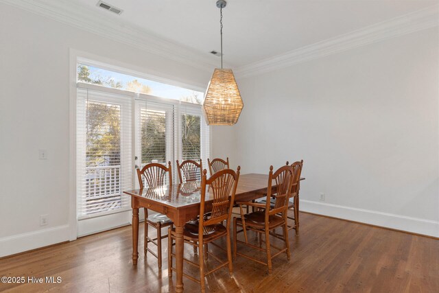 dining area featuring dark hardwood / wood-style floors and ornamental molding