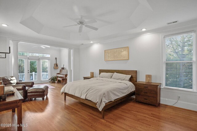 bedroom with ornamental molding, access to outside, a raised ceiling, ceiling fan, and hardwood / wood-style flooring